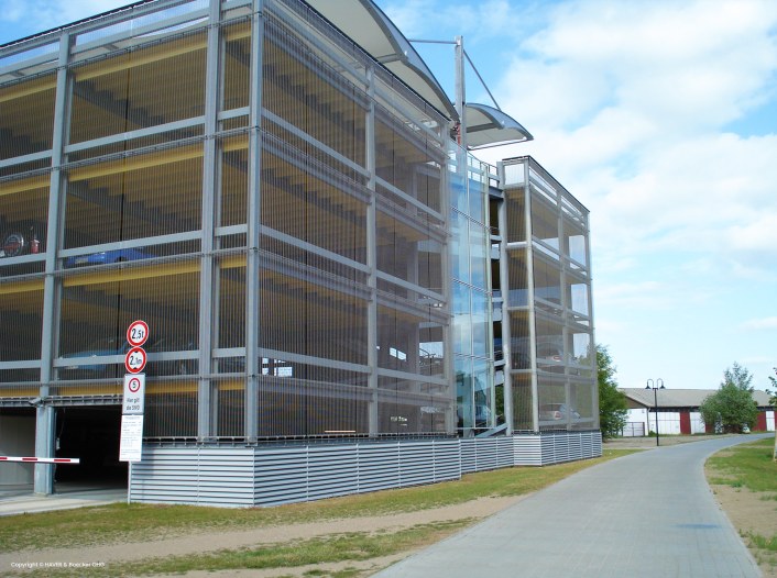 Metal facade of the parking house, wire screens, entrance to the house
