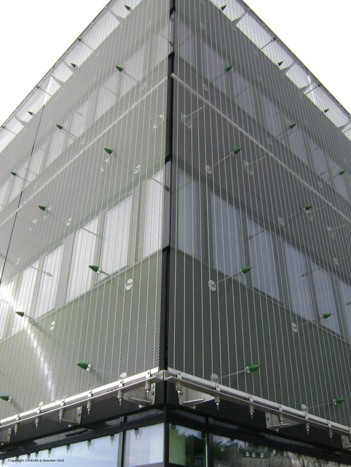 Corner of an office building with a metal facade that serves the purpose of shielding but also a modern look