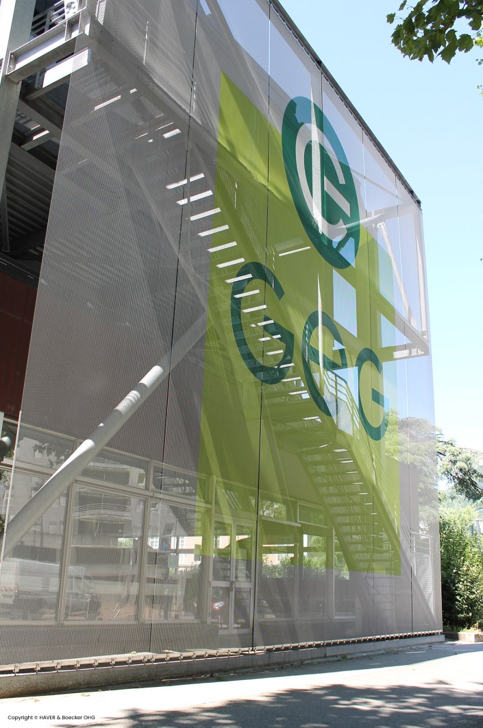 A stretched metal facade using wire fabrics. The logo is displayed on the metal facade.