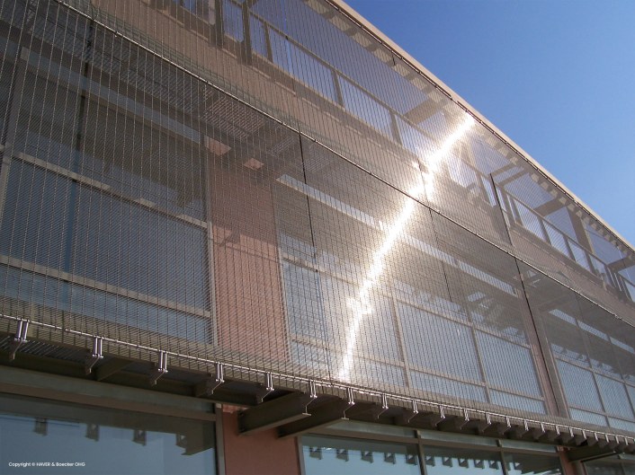 Building with metal facade, wire mesh used to achieve a modern look