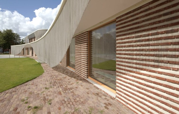 Facade shading in the form of a metal curtain, using spiral nets shaped into waves